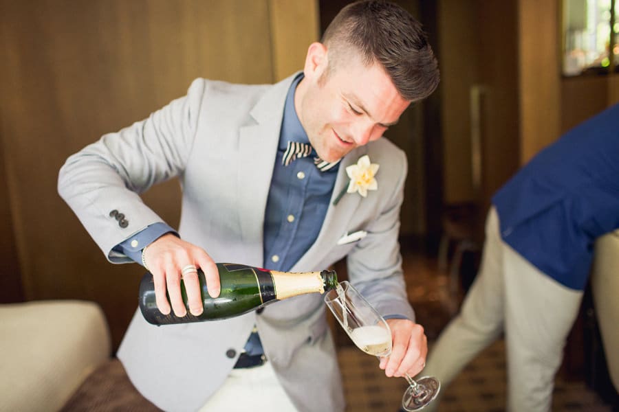 Groom pouring champange in Loden Hotel in Vancouver