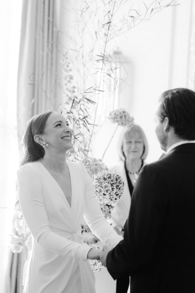 Bride and groom holding hands during their wedding ceremony.