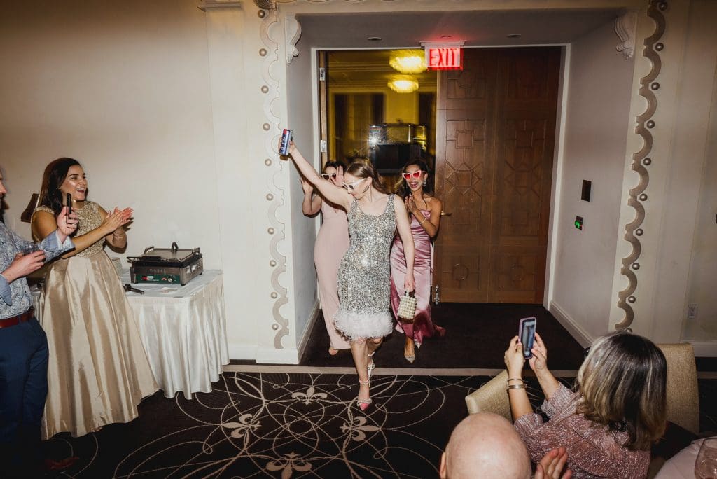 Stunning bride in a shimmering silver dress, making her grand entrance to the party